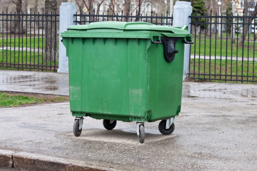 Skip hire vehicle at a depot with a skip bin being loaded
